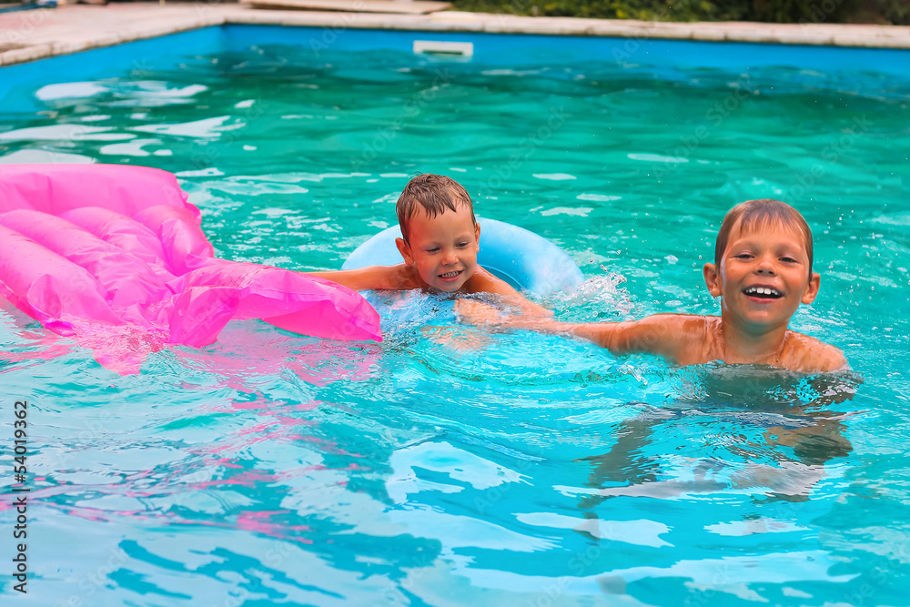 Fototapeta premium Two brothers are swimming in the pool
