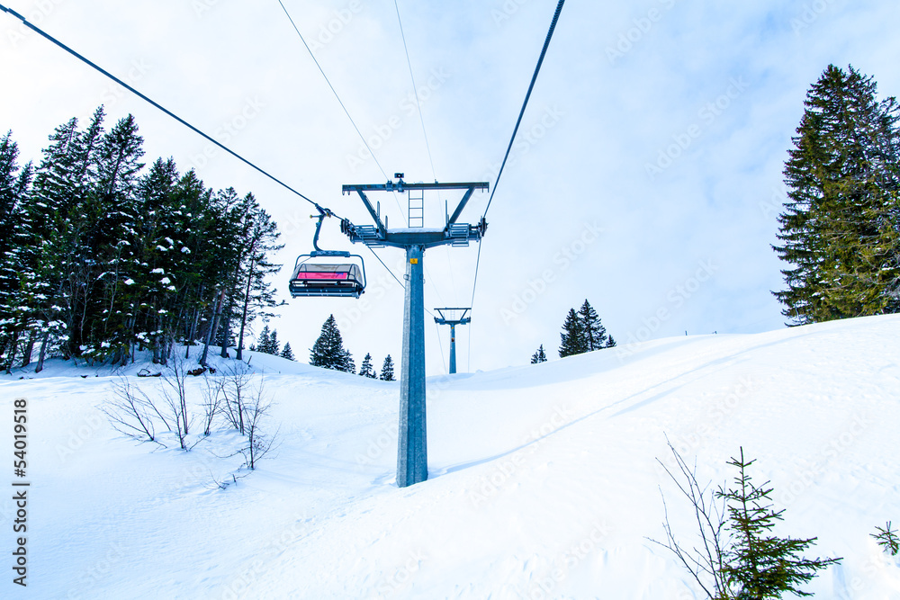 Obraz premium Ski lift with chairs. Lift to the top of the mountain at ski re