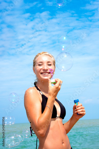Young blonde girl having fun on the beach