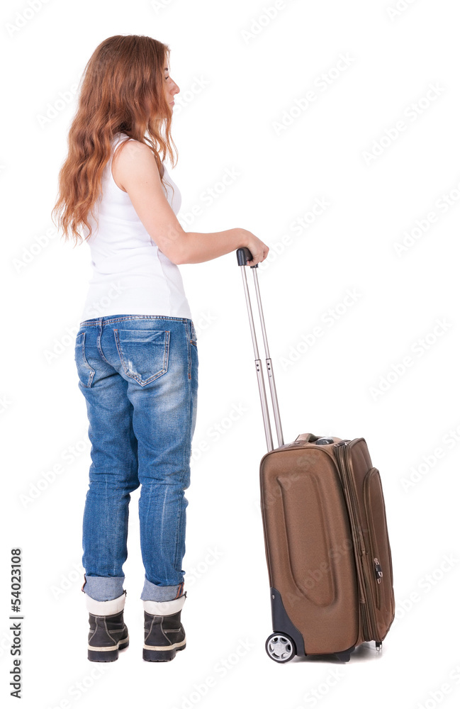 Back view of stylishly dressed woman with suitcase looking up Back view of stylishly dressed woman with suitcase looking up
