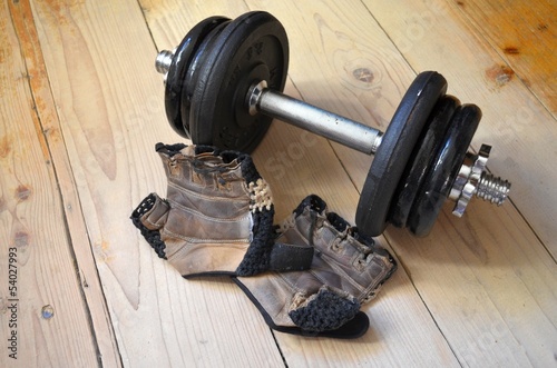 Pair of fitness gloves and dumbbells