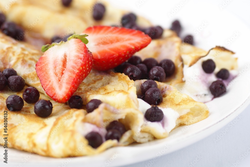 Crepes with cream, strawberries and blueberries. Crepes with cream, strawberries and blueberries.