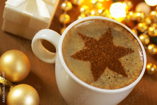 Cup of coffee with cinnamone star and Christmas decorations. photo