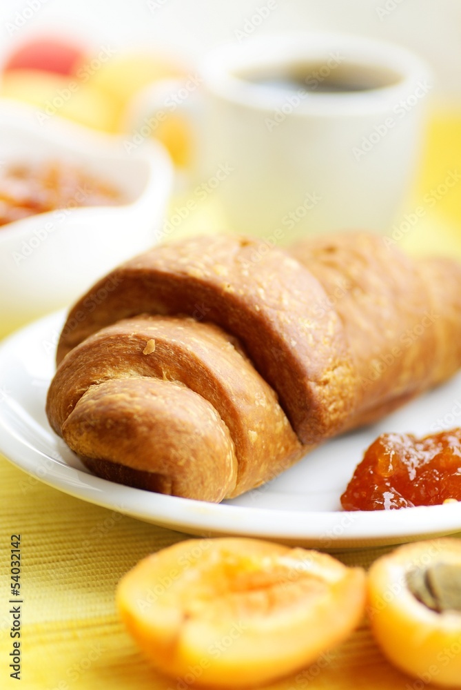Croissant, apricot jam, apricots and coffee