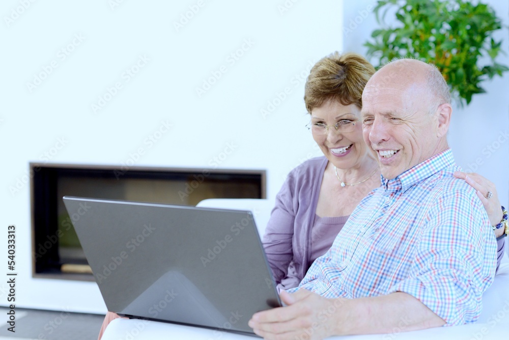 Seniorenpaar Best Ager freut sich mit Laptop