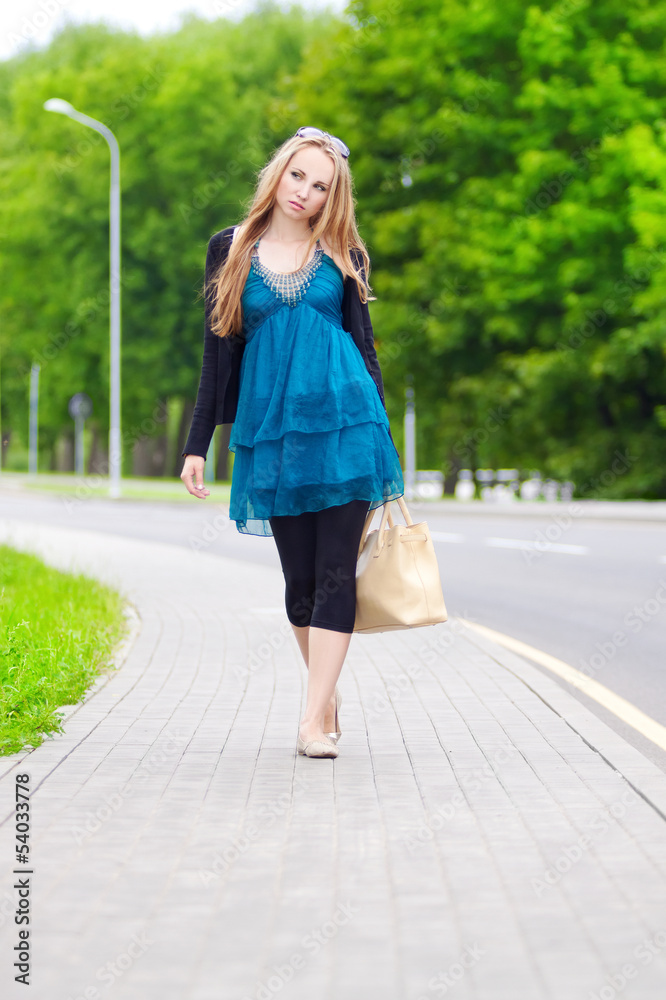 young woman with walking on the sidewalk