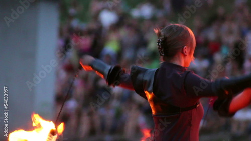 Flame artist perform using burning chain fire pois and sticks