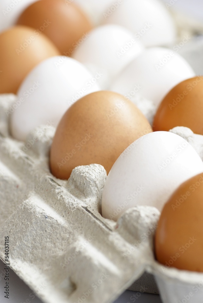 White and brown chicken eggs in carton box. White and brown chicken eggs in carton box.