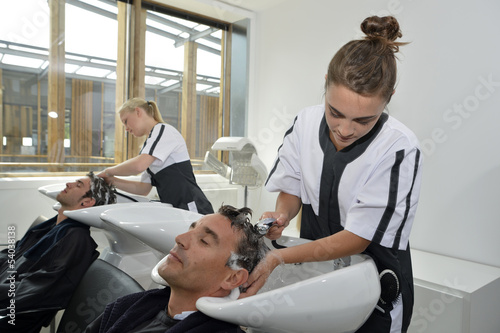 Young women in hair salon washing customer's hair