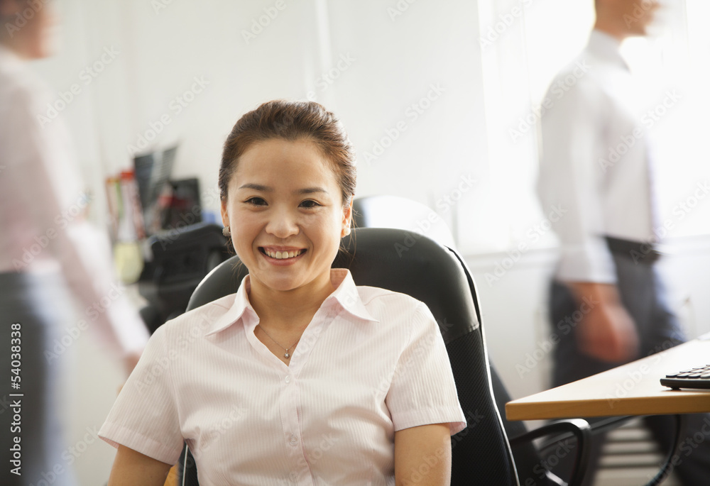 Fototapeta Office worker seating and smiling, portrait