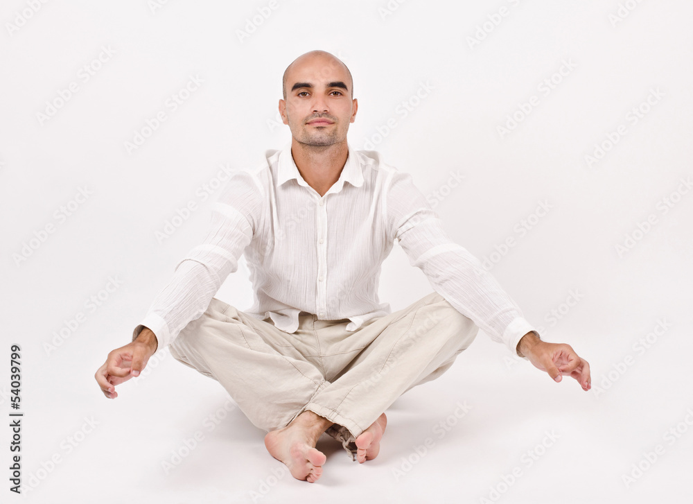 Man dressed in white sitting relaxing and doing yoga. Man dressed in white sitting relaxing and doing yoga.