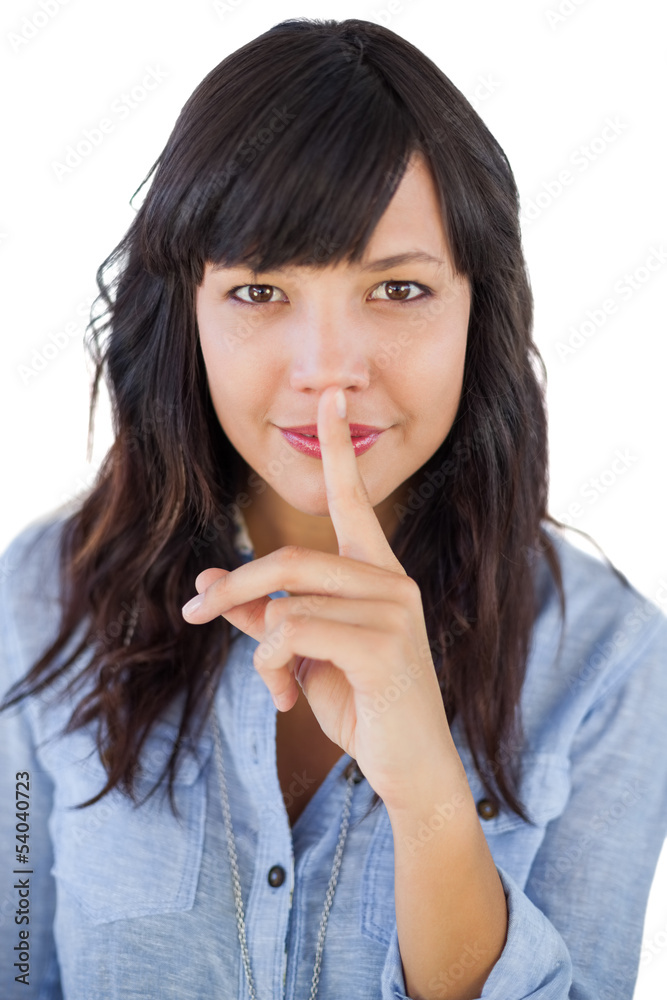 Brunette putting finger on her mouth for silence