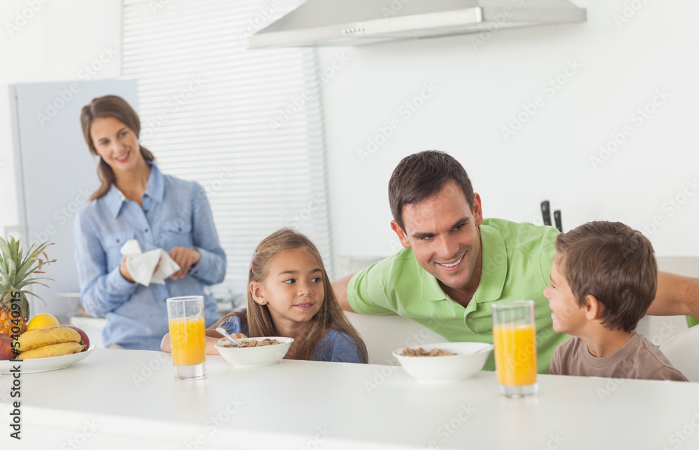 Father speaking to his children who are having breakfast Father speaking to his children who are having breakfast