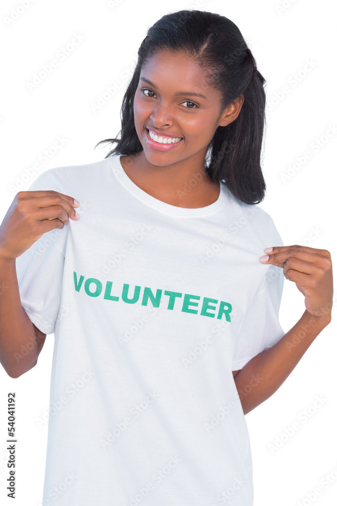 Young woman wearing volunteer tshirt and pointing to it