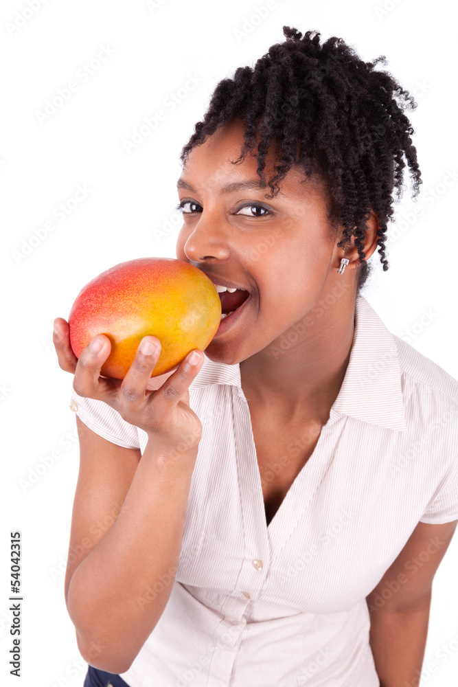 Young happy black / african american woman eating fresh mango Young happy black / african american woman eating fresh mango
