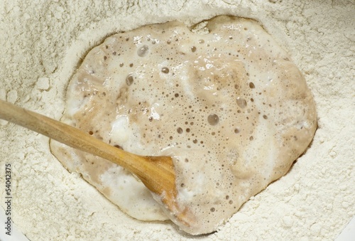 Flour, leaven and wooden spoon..
