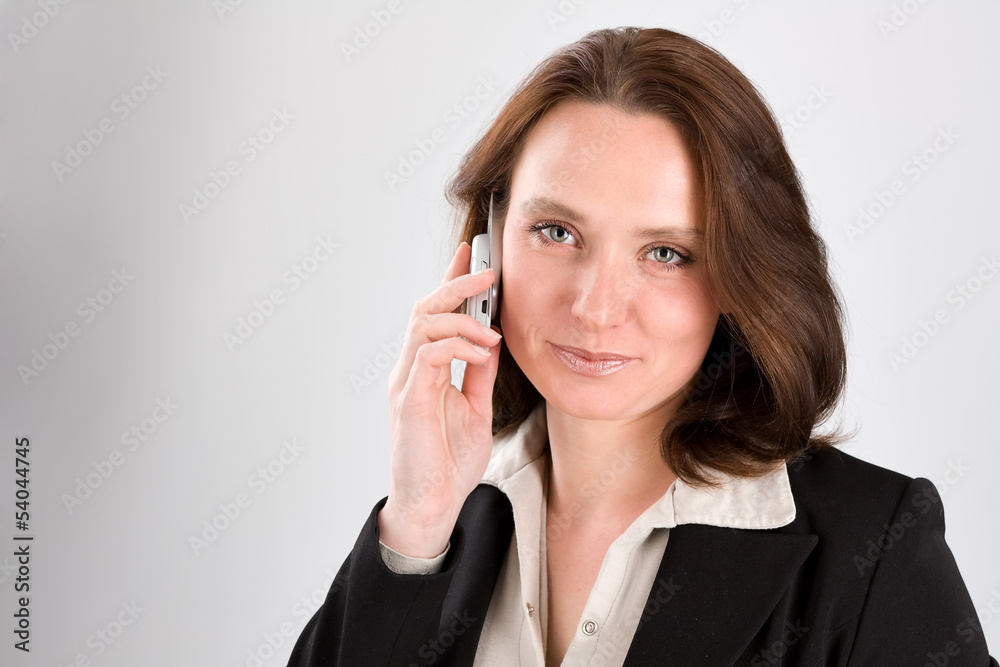 The business woman speaks by phone on gray The business woman speaks by phone on gray