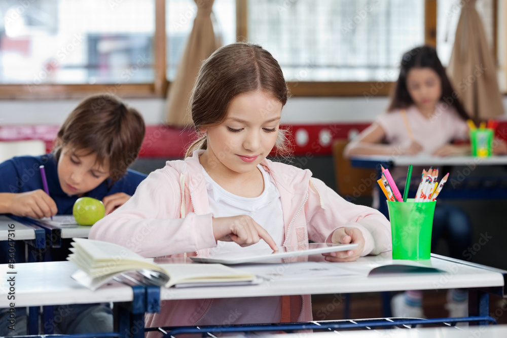 Schoolgirl Using Digital Tablet At Desk Schoolgirl Using Digital Tablet At Desk