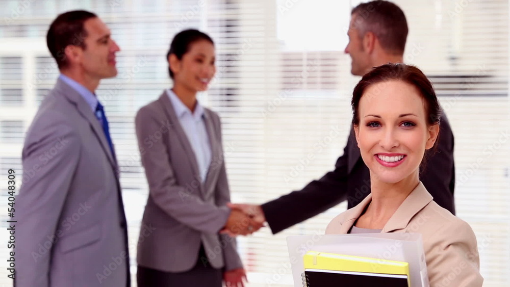 Confident businessman looking at camera while colleagues are Confident businessman looking at camera while colleagues are