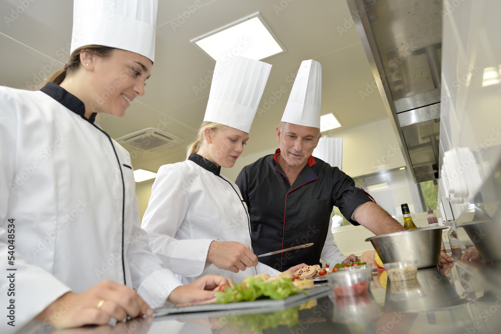 Team of young chefs preparing delicatessen dishes