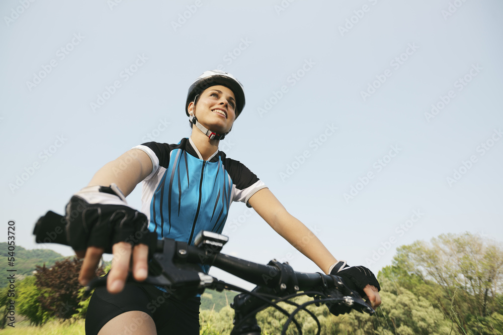 young woman training on mountain bike and cycling in park
