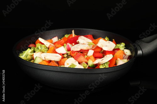 Vegetable ragout in pan, isolated on black