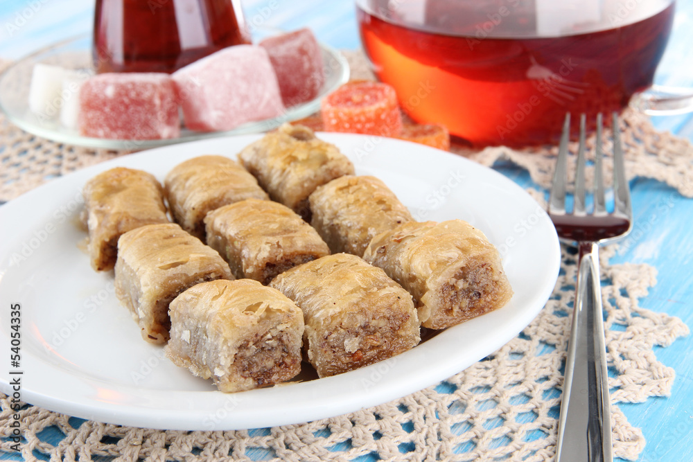 Sweet baklava on plate with tea on table Sweet baklava on plate with tea on table