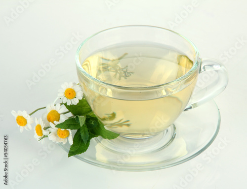 Cup of herbal tea with wild camomiles and mint, isolated