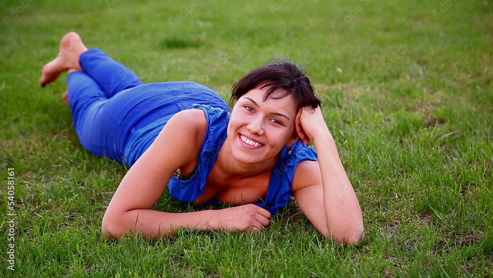 young beautiful girl lies on the grass in the park 1 young beautiful girl lies on the grass in the park 1