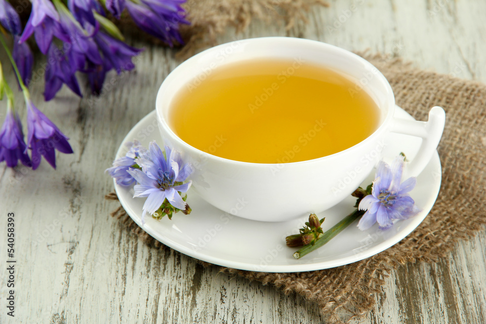 Cup of tea with chicory, on wooden background Cup of tea with chicory, on wooden background