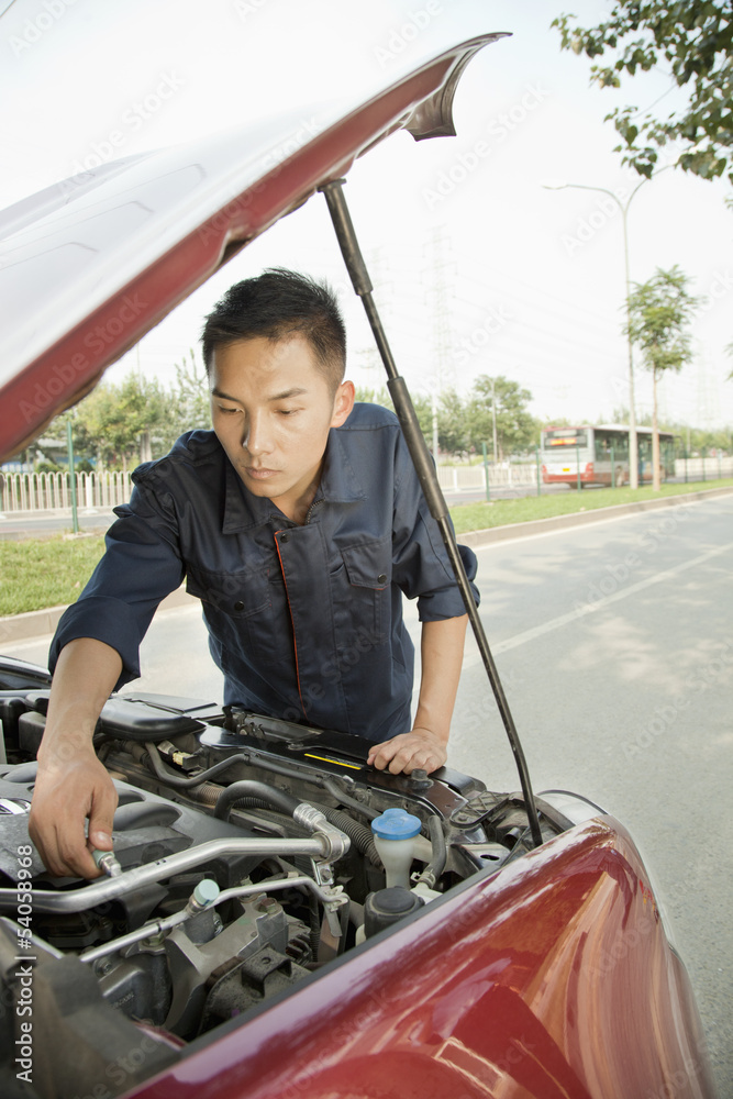 Mechanic Fixing Car by Roadside