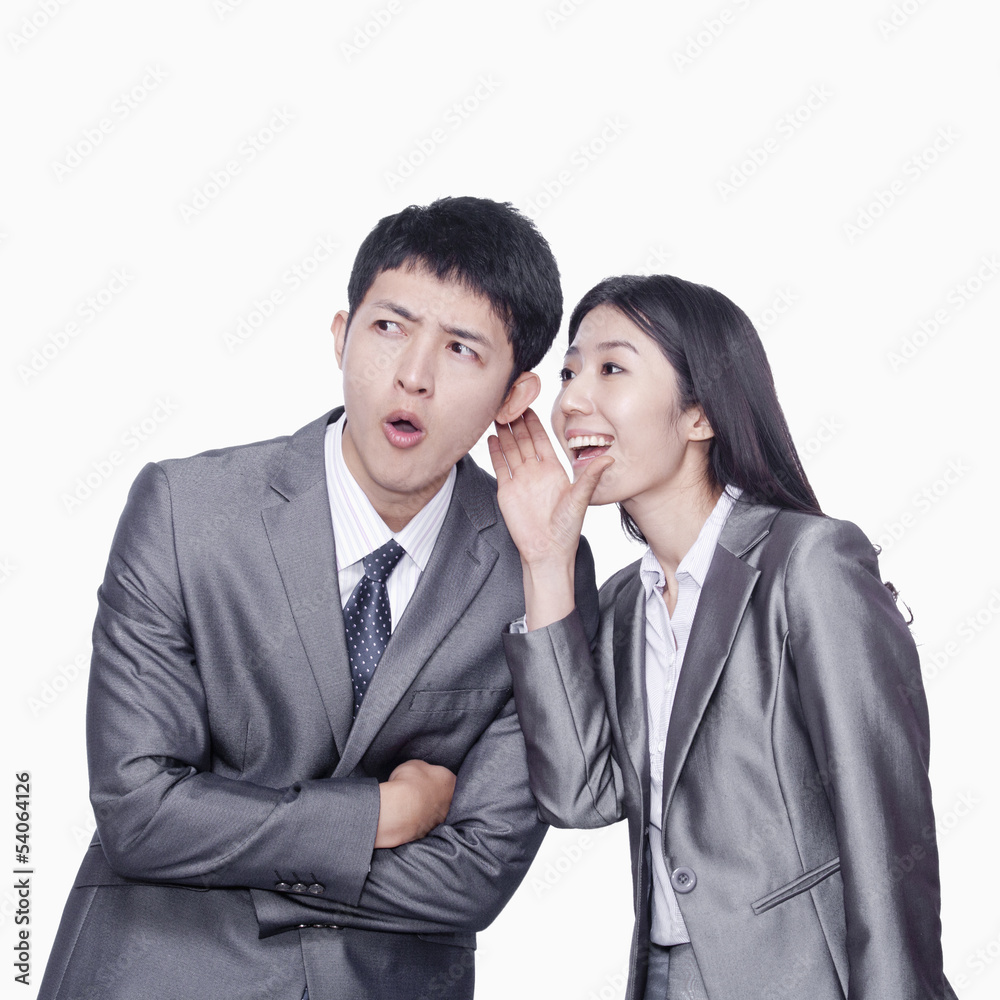 Businesswoman whispering in businessman's ear Businesswoman whispering in businessman's ear