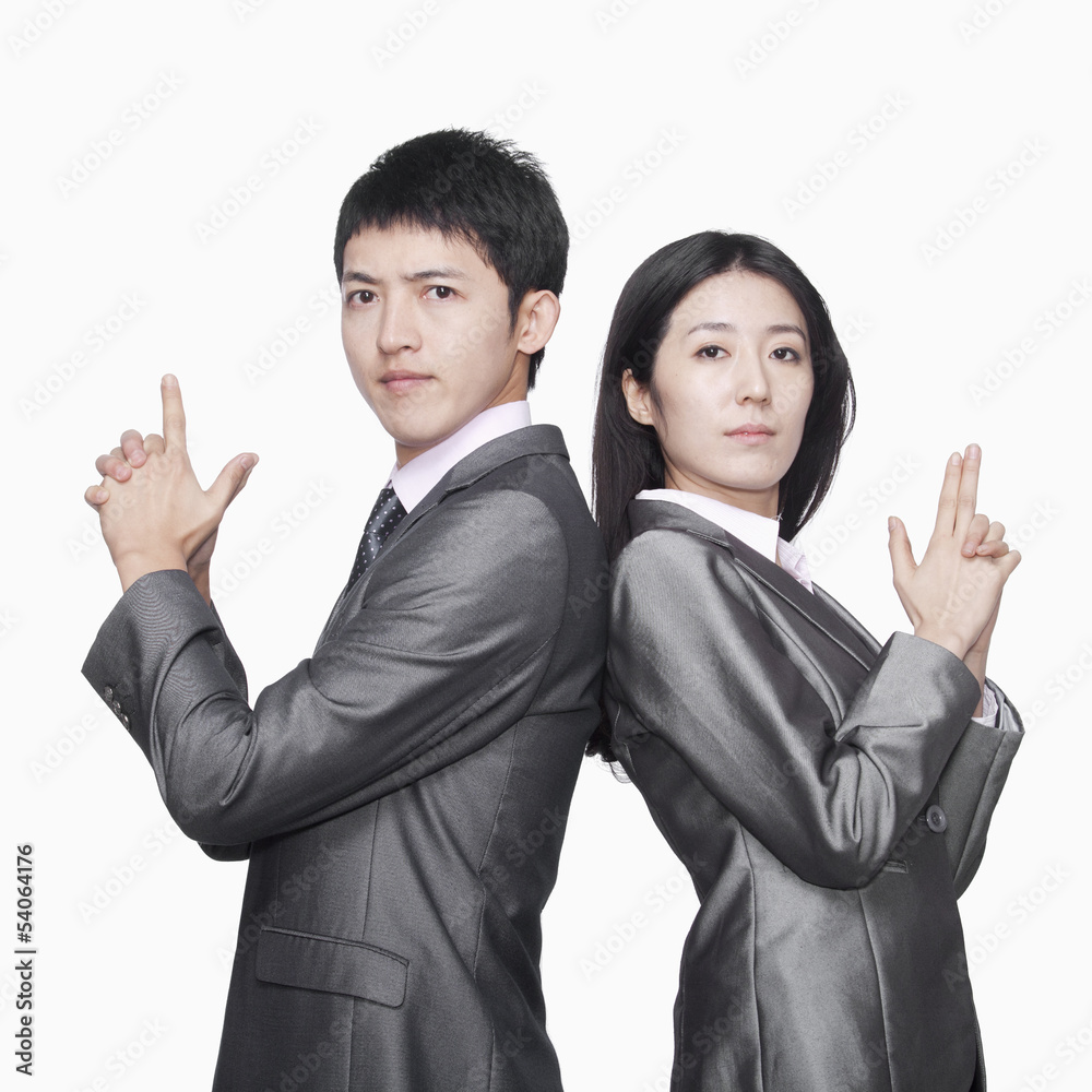 Businessman and businesswoman standing back to back and showing hand guns Businessman and businesswoman standing back to back and showing hand guns