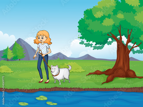 A woman with a dog walking along the river