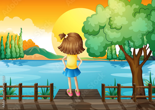 A girl standing facing at the river