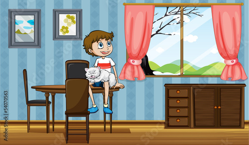 A boy sitting at the table with his cat