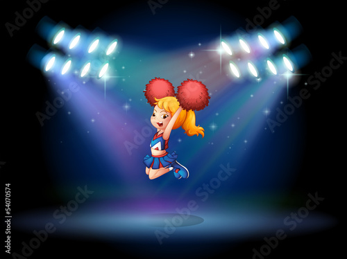 A cheerleader jumping in the middle of the stage
