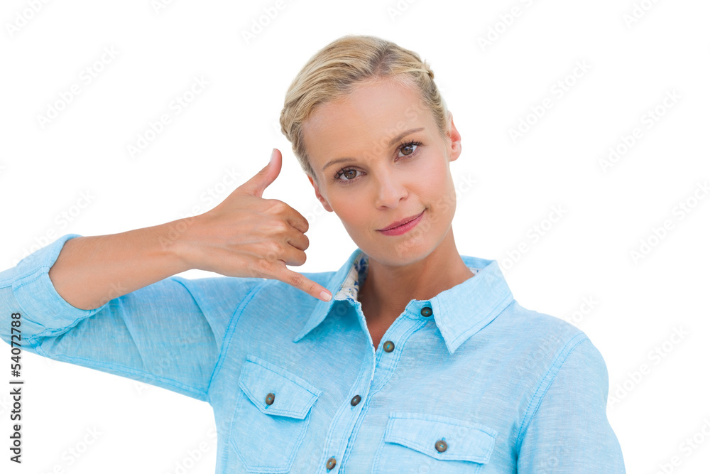 Blonde doing a symbol of phone with her hand and looking at came Blonde doing a symbol of phone with her hand and looking at came