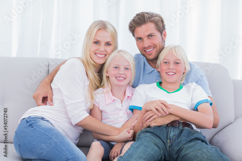Smiling family sitting on couch
