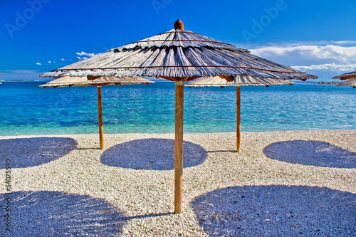 Pebble beach and turquoise sea umbrella