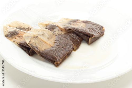 Some removed tea bags on white dish