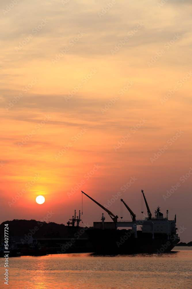 Cargo ship in the harbor at sunset