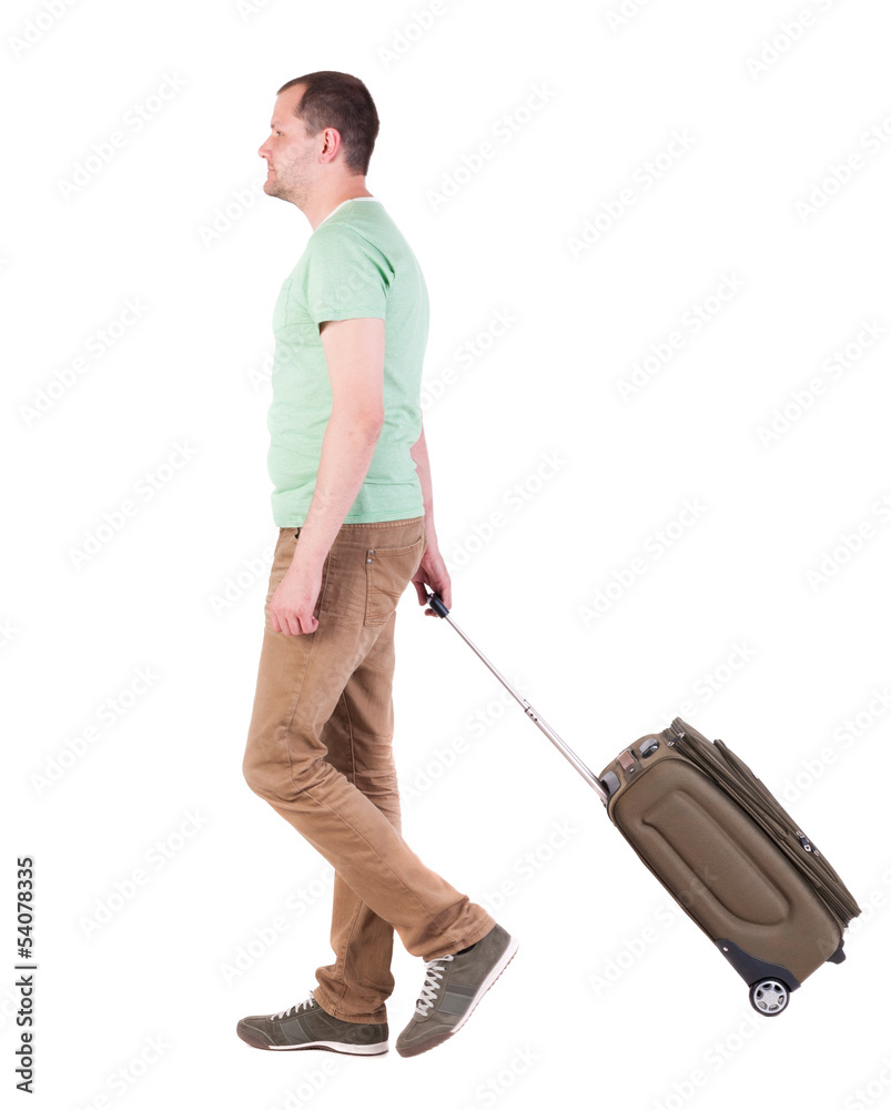 back view of walking man with suitcase. brunette guy in motio back view of walking man with suitcase. brunette guy in motio