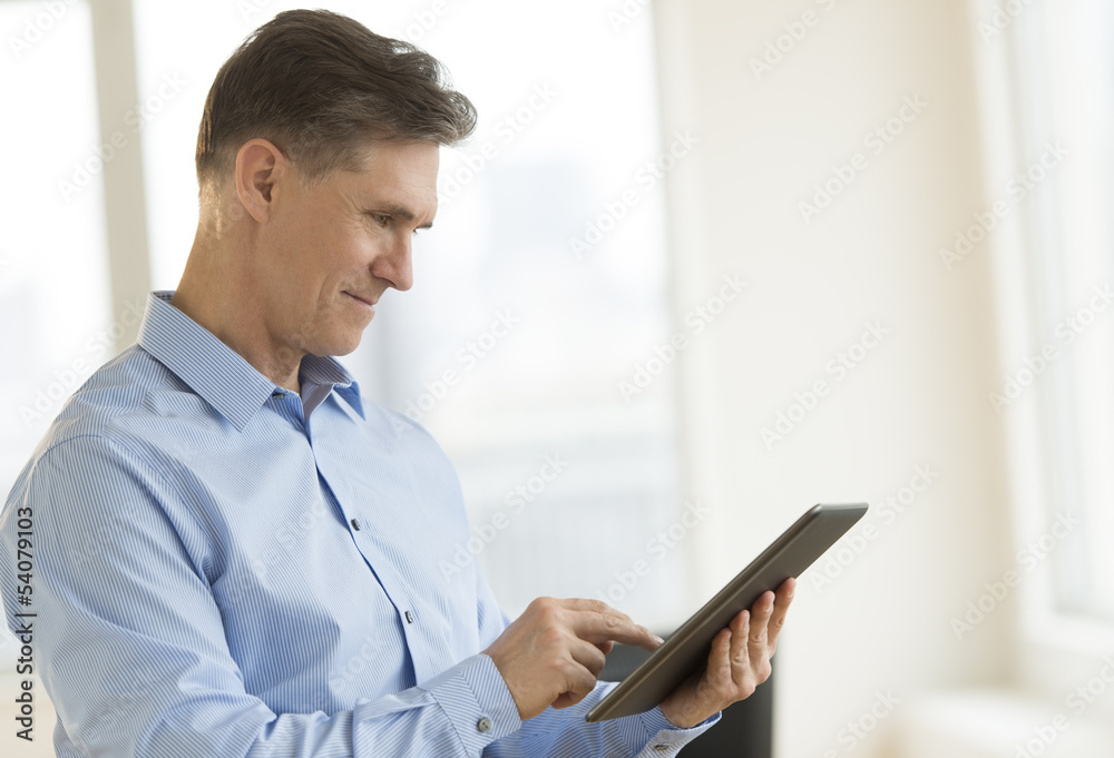 Businessman Smiling While Using Tablet