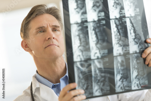 Male Doctor Examining X-Ray Report