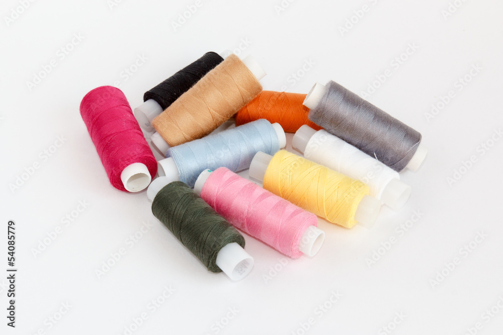 Multy coloured bobbins of thread on white Multy coloured bobbins of thread on white