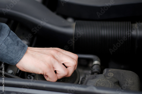 Hand of mechanic working on a car's motor