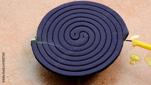  A man is trying to light the purple mosquito repellent incense 