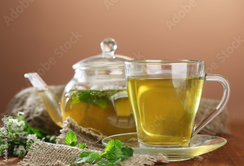 Cup and teapot of herbal tea with fresh mint flowers