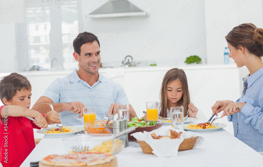 Family eating pasta with sauce for the dinner